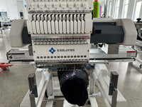 Kreatek BL-1501 industrial embroidery machine with 15-needle high-speed head stitching a black cap in a factory setting