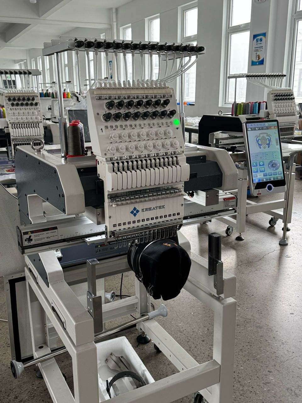 Kreatek III BL-1501 high-speed industrial embroidery machine with touchscreen, 12/15 needles, and multi-language support for caps and textiles.