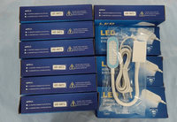 Blue boxed LED sewing machine lamps with white power cords and USB or plug options displayed on a surface