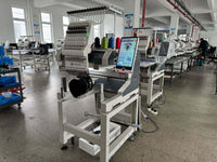 Kreatek III BL-1501 industrial embroidery machine in factory setting with touchscreen control and cap embroidery setup