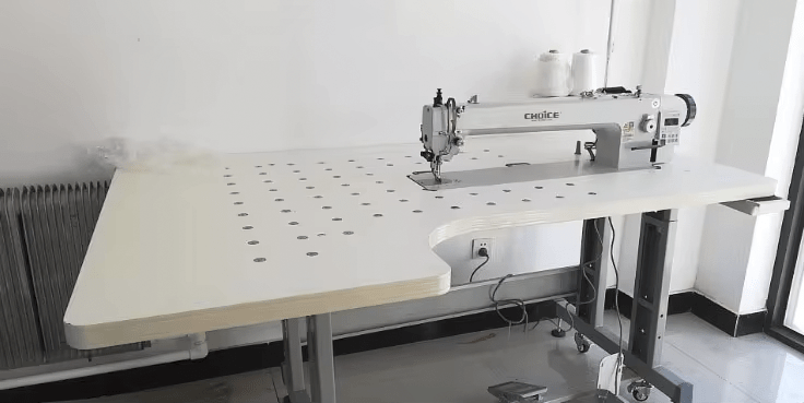 Industrial sewing machine Model GC0303-560-D4 with long 56cm arm, computerized direct drive system, top and bottom feeding, alternating transport, autotrimmer, and automatic foot lift on a sturdy white worktable.