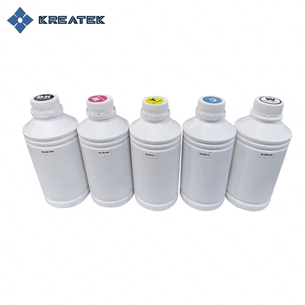 Bottles of Kreatek DTF-blekk in CMYK and white colors for digital textile printing.